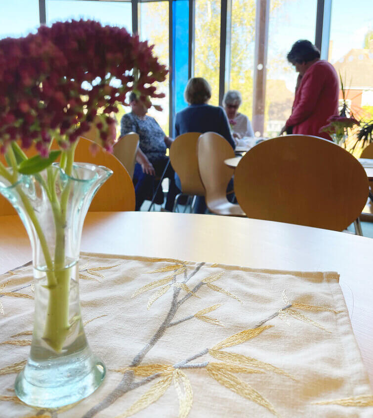 Flowers in the foreground, with people chatting in the background